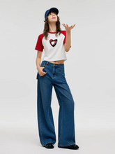 a lady wears a dark blue baggy jeans with a red and white raglan sleeves T-shirt